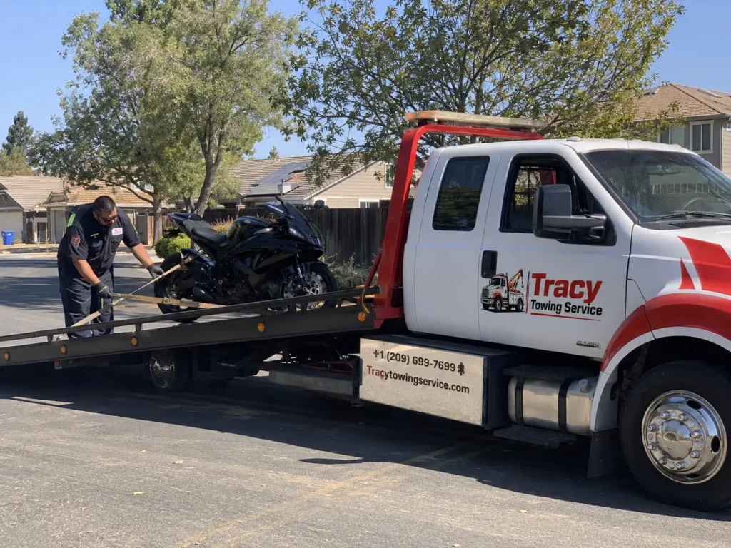 tracy towing service technician securing motorcycle on flatbed towing truck for transportation in tracy